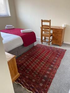 a bedroom with a bed and a chair and a rug at Field Avenu in Kent