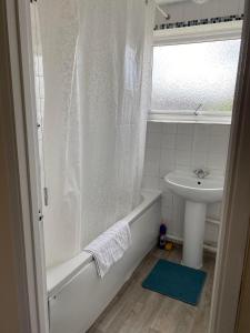 a bathroom with a tub and a sink and a shower at Field Avenu in Kent