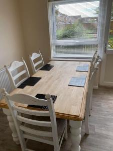 a dining room table with white chairs and a large window at Field Avenu in Kent