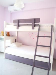 a bunk bed with a ladder in a room at Patroclos SeaView in Sounio