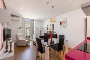 a living room with a dining room table and chairs at BNBHolder Apartamentos en Sol Superior 2 in Madrid
