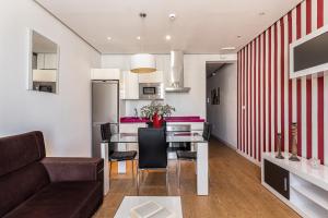 a kitchen and living room with a table and chairs at BNBHolder Apartamentos en Sol Superior 2 in Madrid