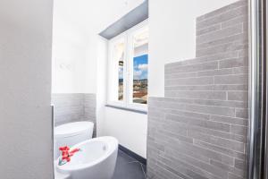 uma casa de banho com um lavatório branco e uma janela em Home of Genoa's executioner em Génova