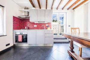 uma cozinha com electrodomésticos brancos e uma mesa de madeira em Home of Genoa's executioner em Génova