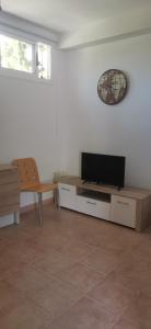 ein Wohnzimmer mit einem Flachbild-TV und einem Tisch in der Unterkunft Apartamento zona Parque Comercial in Mojácar
