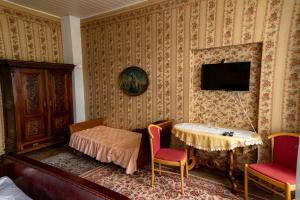 Zimmer mit einem Tisch und einem TV an der Wand in der Unterkunft Pension Zámek Rudník in Rudník