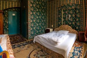 1 dormitorio con 1 cama en una habitación con papel pintado en Pension Zámek Rudník en Rudník