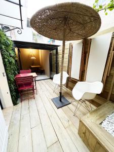 um pátio com uma mesa, cadeiras e um guarda-sol em LE PECHEUR DE CASSIS em Cassis
