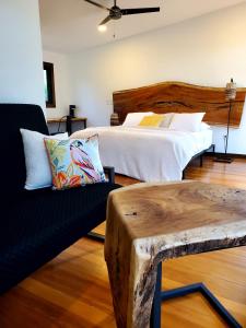 a bedroom with a bed and a couch and a table at Yumas Riverfront Lodge in San Ignacio