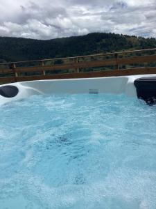 ein großer Pool mit blauem Wasser und einem Holzzaun in der Unterkunft Les Chalets Bambi & Jacuzzi privatif in La Bresse