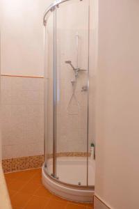 een douche met een glazen deur in de badkamer bij La Siesta in Poggibonsi