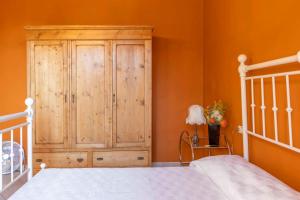 a bedroom with a wooden cabinet next to a bed at La Siesta in Poggibonsi