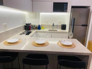 una cocina con una mesa con copas de vino. en Apartamento novo de alto padrão e aconchegante#223 en Brasilia