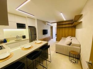 a kitchen and living room with a counter and a couch at Apartamento novo de alto padrão e aconchegante#223 in Brasilia