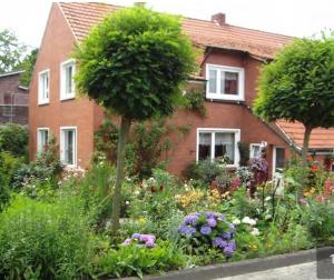 a garden in front of a house with flowers at Ferienhaus Didi in Detern
