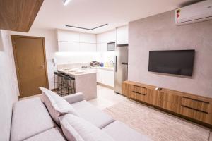 sala de estar con sofá y TV de pantalla plana en Apartamento novo de alto padrão e aconchegante#223, en Brasilia