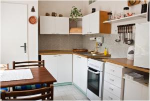 a kitchen with white cabinets and a wooden table at Privat No. 40 in Telč