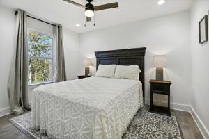 a white bedroom with a bed and a window at Vacation Rental Bay St Louis walk to beach, dining, shopping, and nightlife in Bay Saint Louis