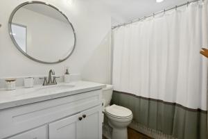 a white bathroom with a sink and a mirror at Vacation Rental Old Town Bay St Louis Unit B in Bay Saint Louis +8 photos