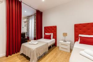 a room with two beds and red curtains at BNBHolder Apartamentos en Sol Confort 8 in Madrid