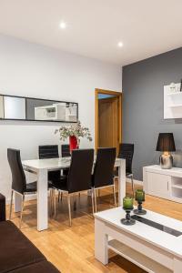 sala de estar con mesa blanca y sillas en BNBHolder Apartamentos en Sol Confort 8, en Madrid