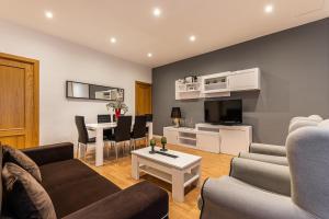 sala de estar con sofá y mesa en BNBHolder Apartamentos en Sol Confort 8, en Madrid