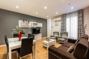 sala de estar con sofá y mesa en BNBHolder Apartamentos en Sol Confort 8, en Madrid