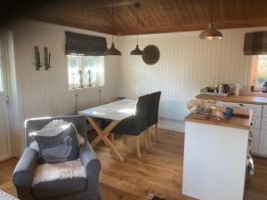 sala de estar con mesa y sillas y cocina en Spurveslottet - cabin by the amazing Trollheimen 