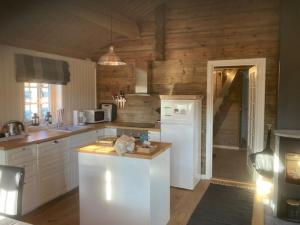 a kitchen with white appliances and wooden walls at Spurveslottet - cabin by the amazing Trollheimen 