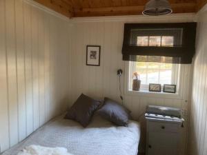 a small bedroom with a bed and a window at Spurveslottet - cabin by the amazing Trollheimen 