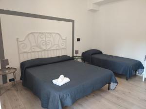 - une chambre avec 2 lits avec des draps bleus et une serviette blanche dans l'établissement Namavistu holiday house, à Catane