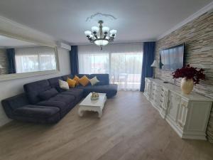 sala de estar con sofá azul y TV en Rancho B 5, en Mijas Costa