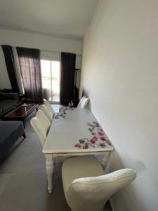 una mesa blanca y sillas en la sala de estar. en amwaj en Dawwār Ruḩayyim