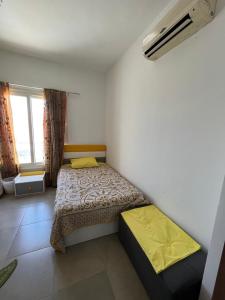 a small bedroom with a bed and a window at amwaj in Dawwār Ruḩayyim