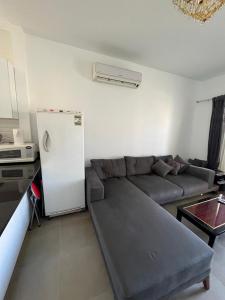 uma sala de estar com um sofá e um frigorífico em amwaj em Dawwār Ruḩayyim