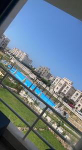 einen Balkon mit Blick auf einen Strand mit Gebäuden in der Unterkunft amwaj in Dawwār Ruḩayyim