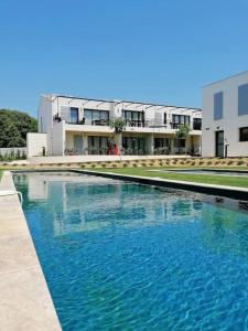 a large pool of blue water in front of a building at Chez Marien in Malaucène