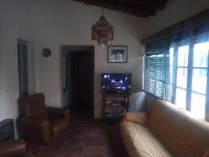 a living room with a couch and a television at Casita de mis viejos in Mendoza