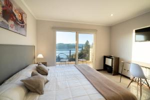 ein Schlafzimmer mit einem großen Bett und einem großen Fenster in der Unterkunft NBH Lacus Boutique Hotel in San Carlos de Bariloche