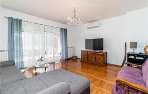 a living room with a couch and a tv at 2 Bedroom Gorgeous Apartment In Pobri in Volosko