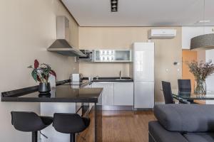 cocina y sala de estar con mesa y sillas en BNBHolder Apartamentos en Sol Deluxe 2, en Madrid