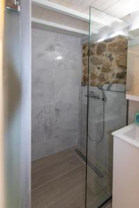 a shower with a glass door in a bathroom at stone house in Mantoúkion