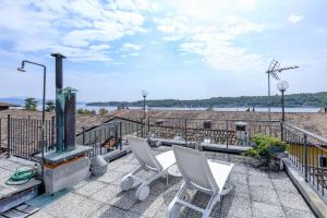 a patio with two white chairs on top of a building at Fantoni luxury Loft in Salò