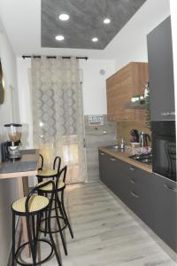 une cuisine avec des chaises et un comptoir avec un évier dans l'établissement La Via Di Mezzo, à Catane