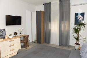 - un salon avec un lit et un bureau dans l'établissement La Via Di Mezzo, à Catane