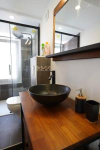 La salle de bains est pourvue d'un lavabo noir sur un comptoir en bois. dans l'établissement F2 Type LOFT à Ajaccio, à Ajaccio