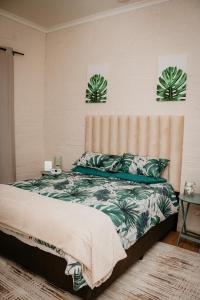a bedroom with a bed with green plants on it at Mooi Uitsig Lodge in Paarl