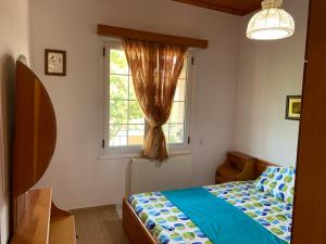a bedroom with a bed and a window at Vasilis home apartment in Mazarakiá