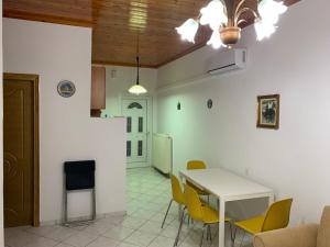 uma sala de jantar com uma mesa branca e cadeiras amarelas em Vasilis home apartment 