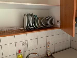 a kitchen with plates on a shelf above a sink at Vasilis home apartment in Mazarakiá +18 photos